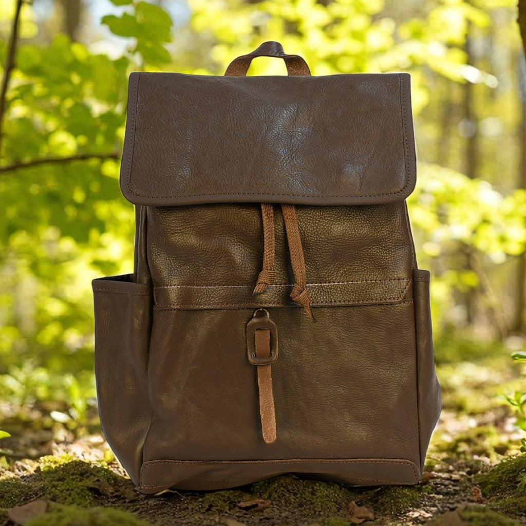 Brown modern rugged leather backpack in a forest setting