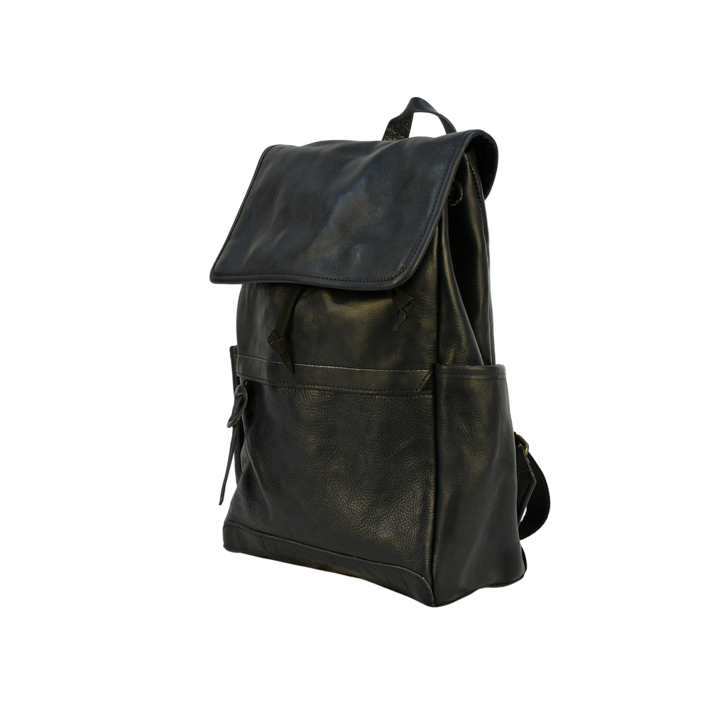Dark leather modern rugged backpack on a wooden surface with books and a stone wall background