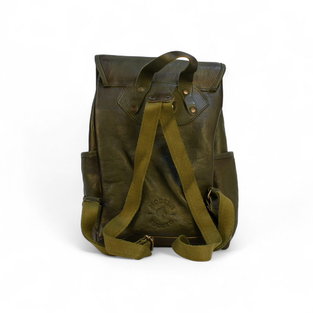 Green leather modern rugged backpack on a wooden table with a blurred indoor background