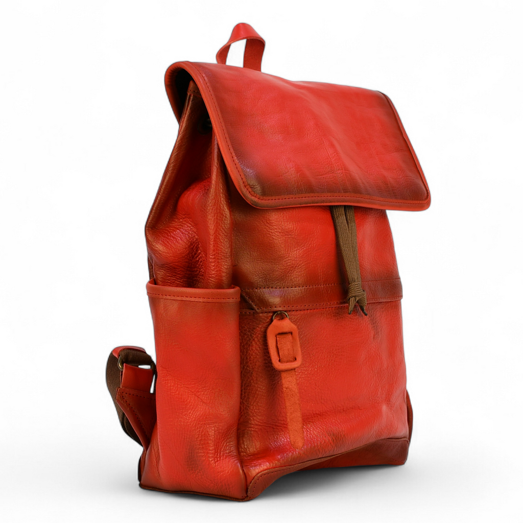 Red modern rugged leather backpack on a wooden surface