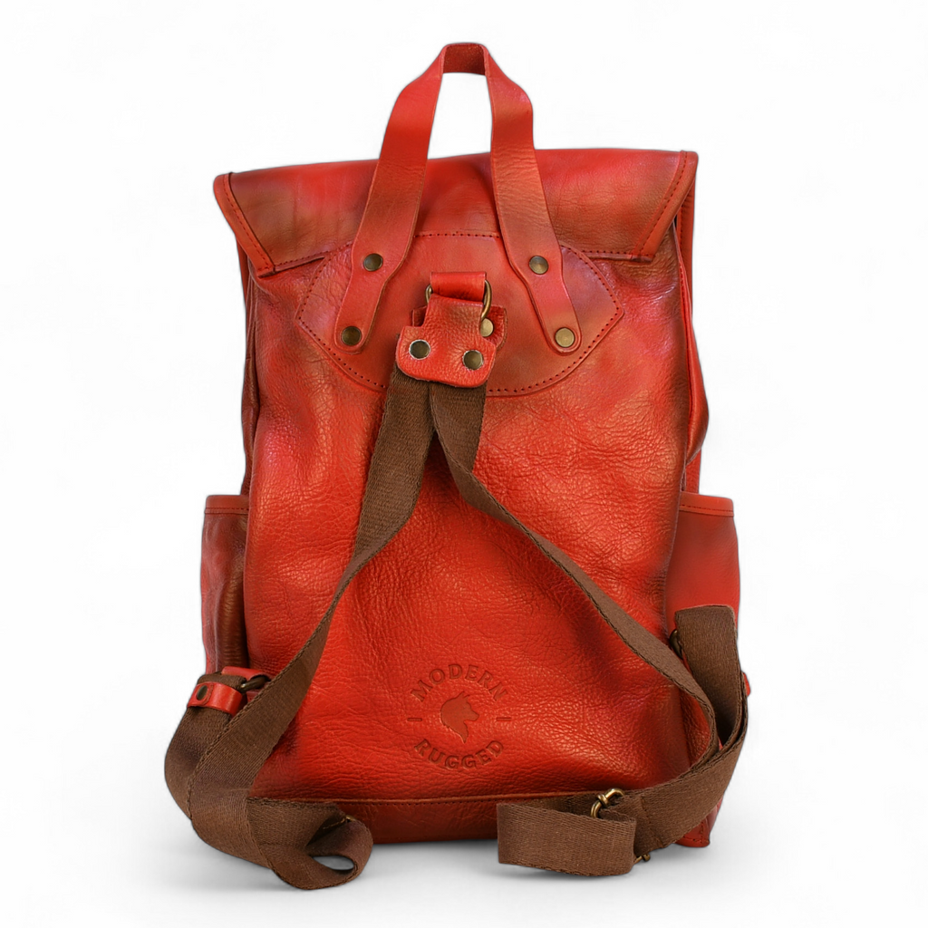 Red modern rugged leather backpack on a wooden surface