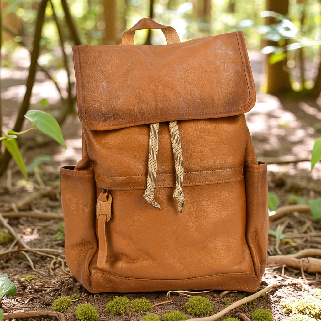 Brown modern rugged leather backpack on a forest floor