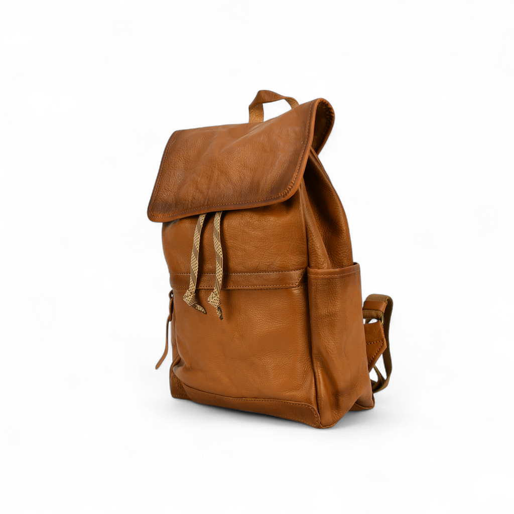 Brown modern rugged leather backpack on a forest floor