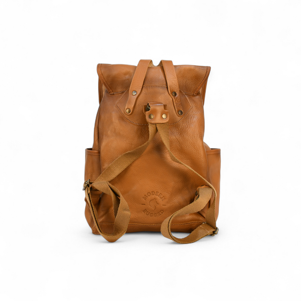 Brown modern rugged leather backpack on a forest floor