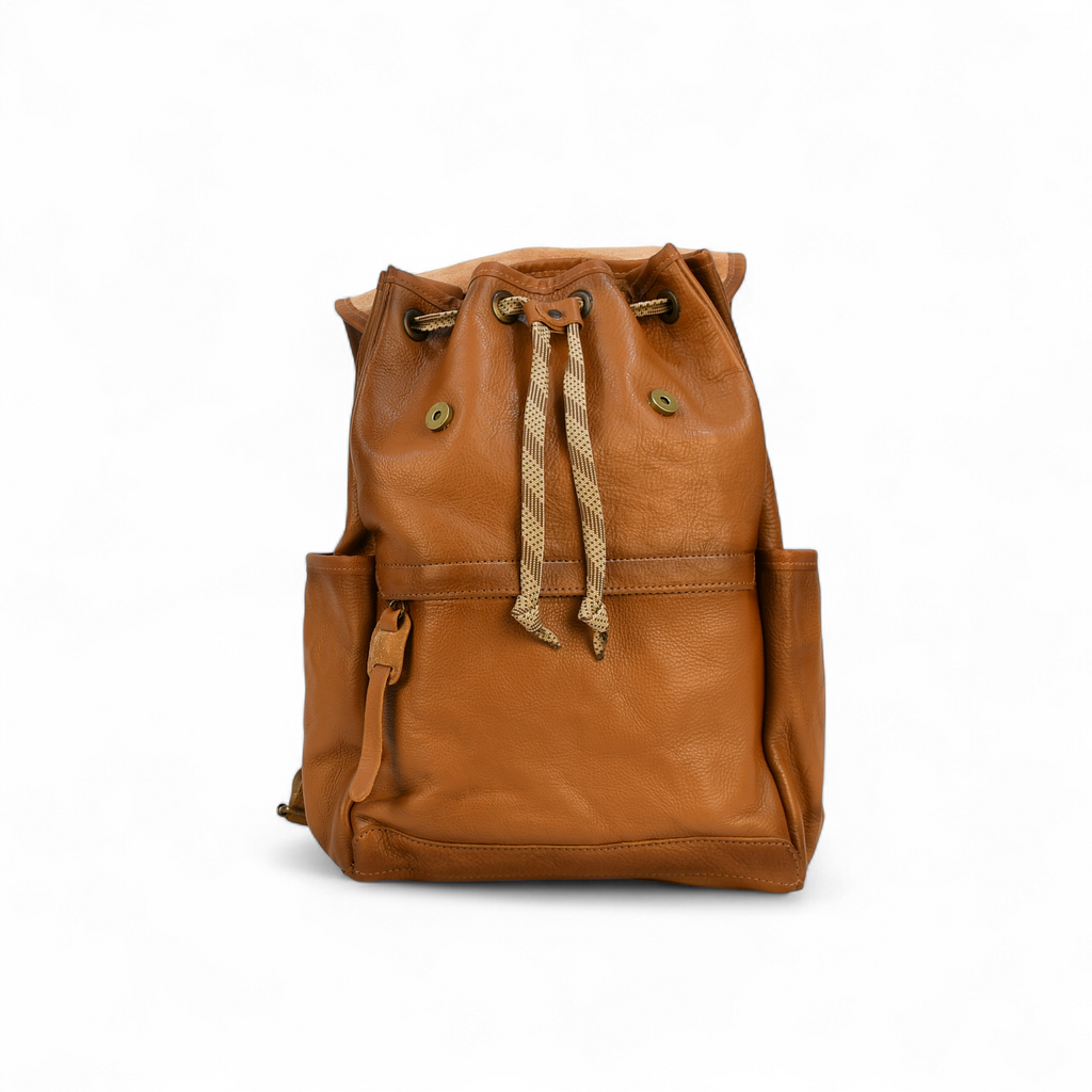 Brown modern rugged leather backpack on a forest floor