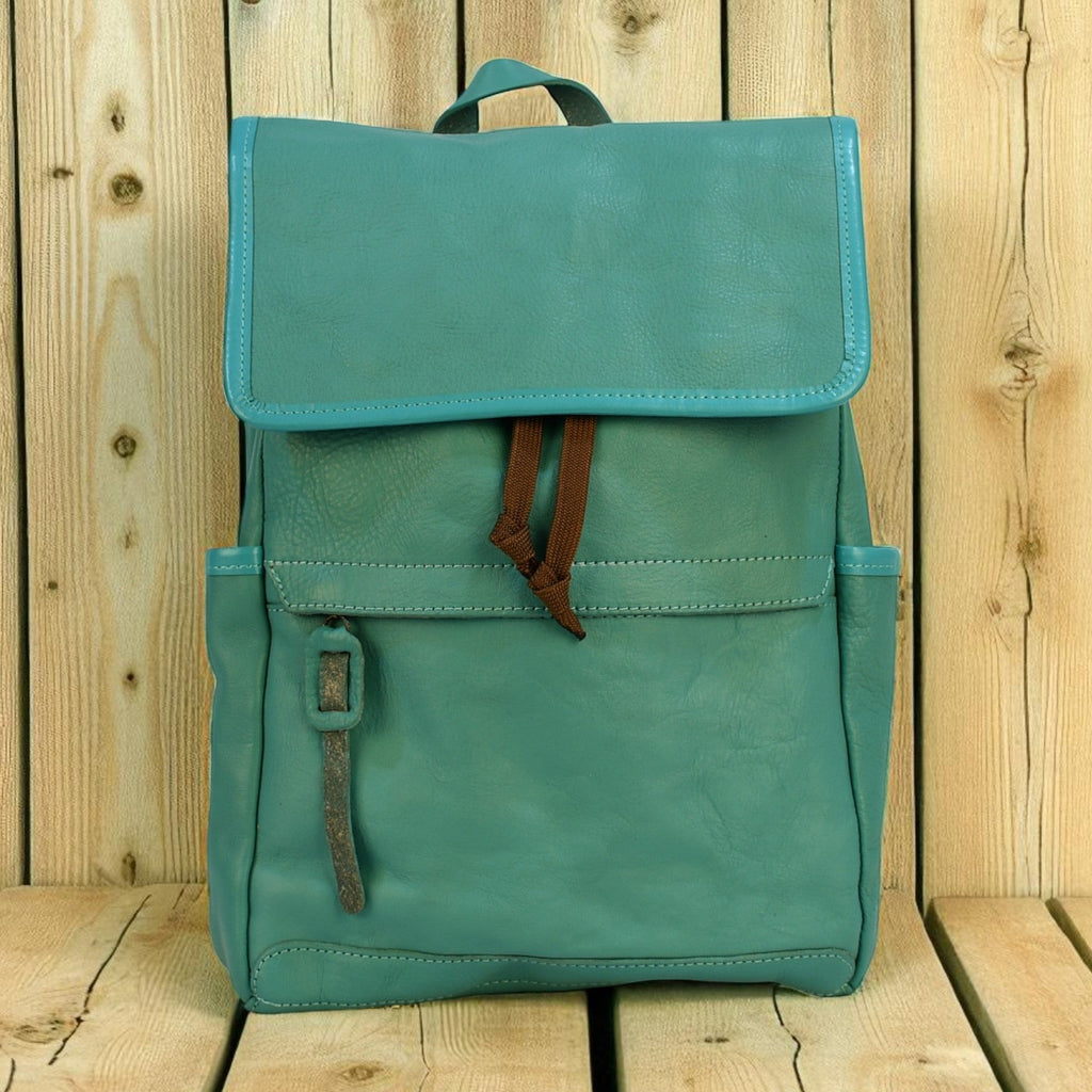 Teal modern rugged backpack with brown straps on a wooden surface
