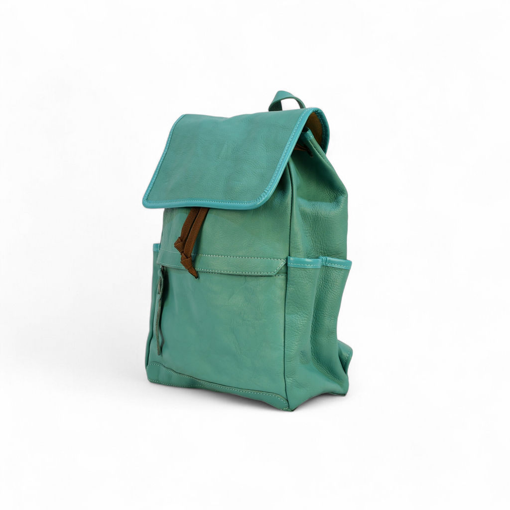 Teal modern rugged backpack with brown straps on a wooden surface