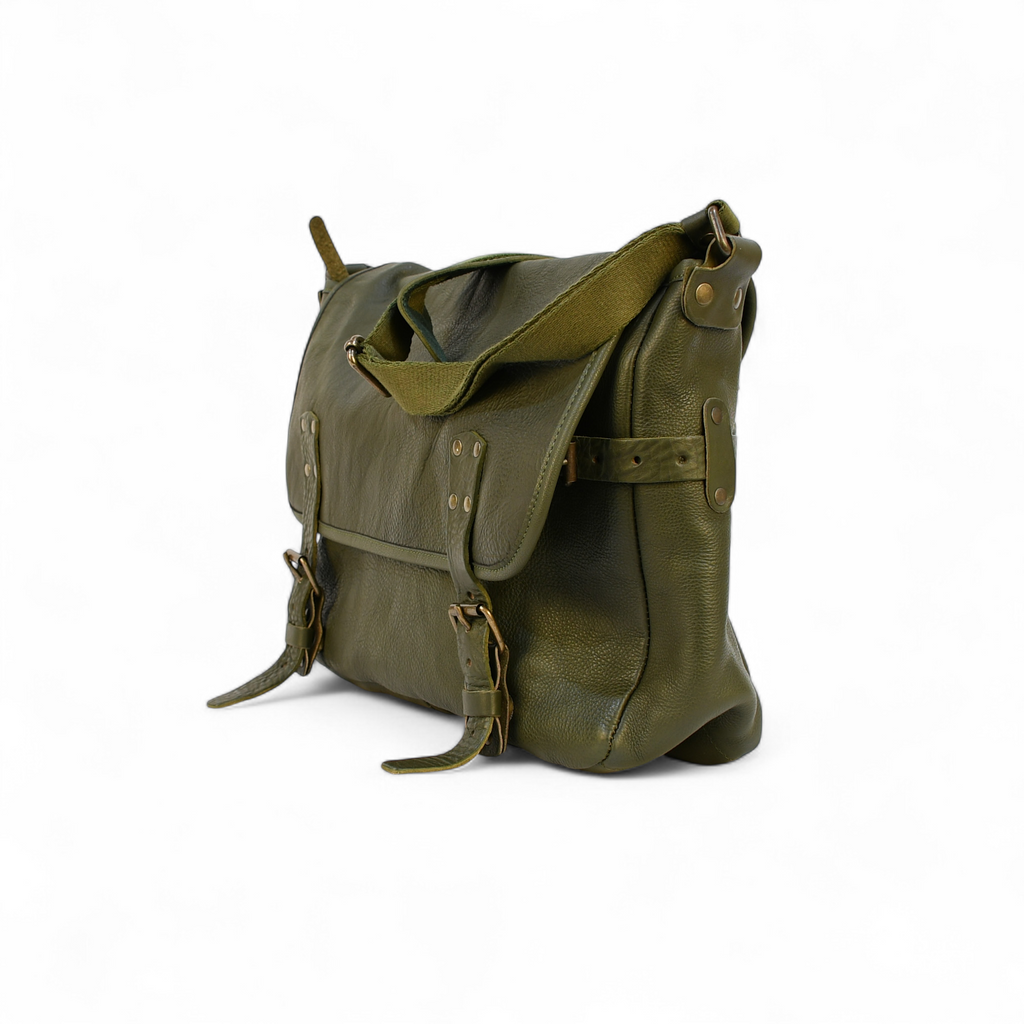 Green leather modern rugged messenger bag on a wooden surface with vintage books in the background