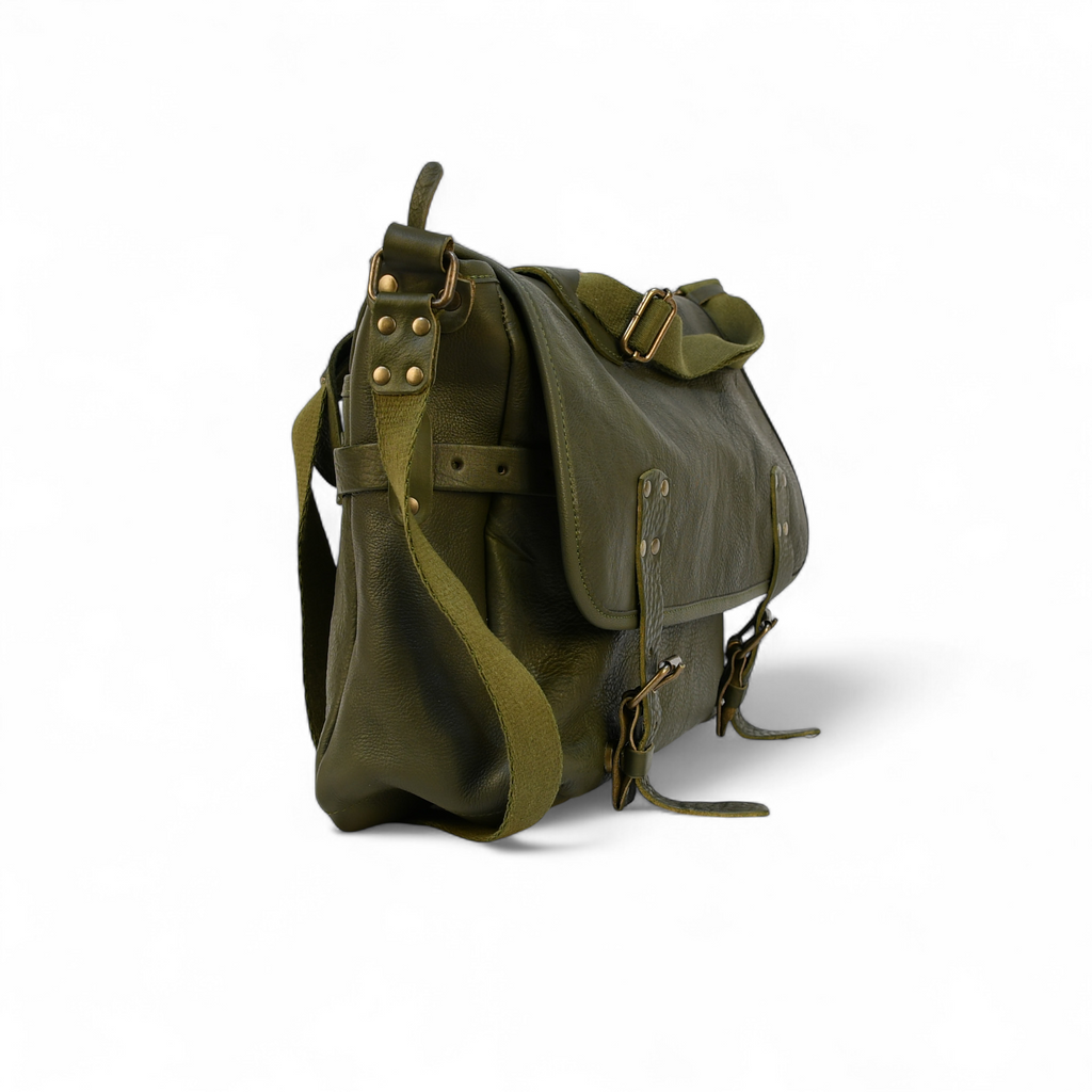 Green leather modern rugged messenger bag on a wooden surface with vintage books in the background