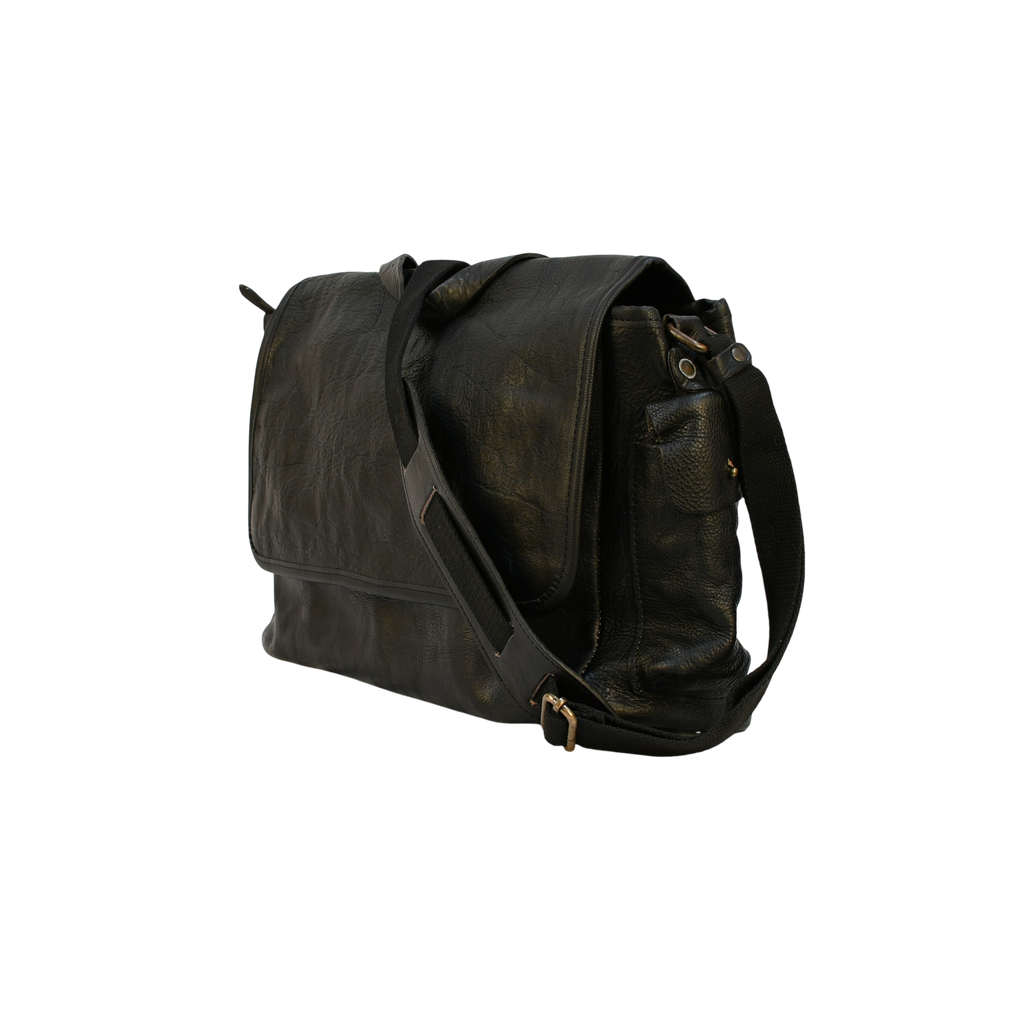 Black modern rugged leather bag with a black strap on a stone pavement street.