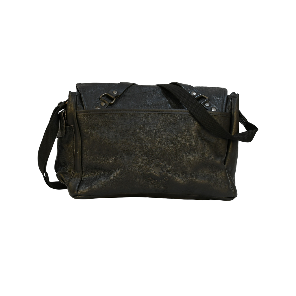 Black modern rugged leather bag with a black strap on a stone pavement street.