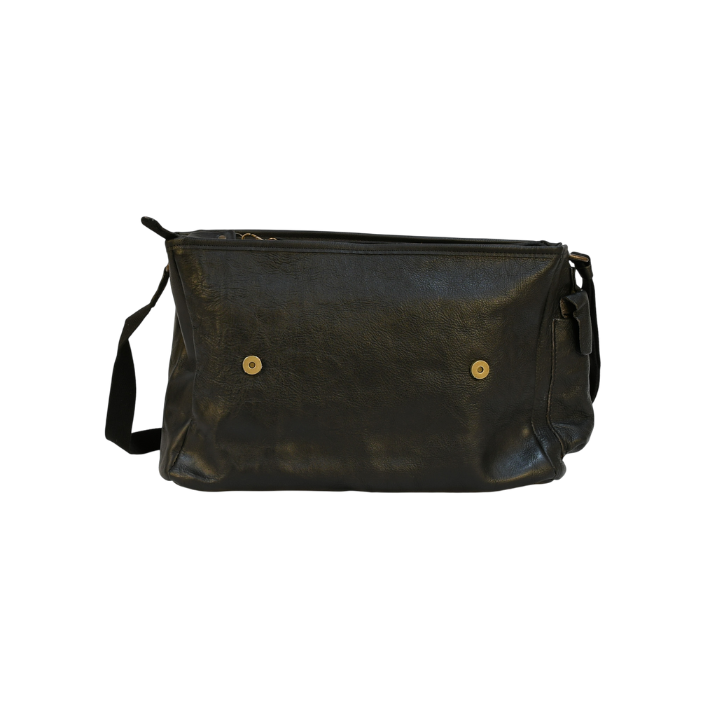 Black modern rugged leather bag with a black strap on a stone pavement street.