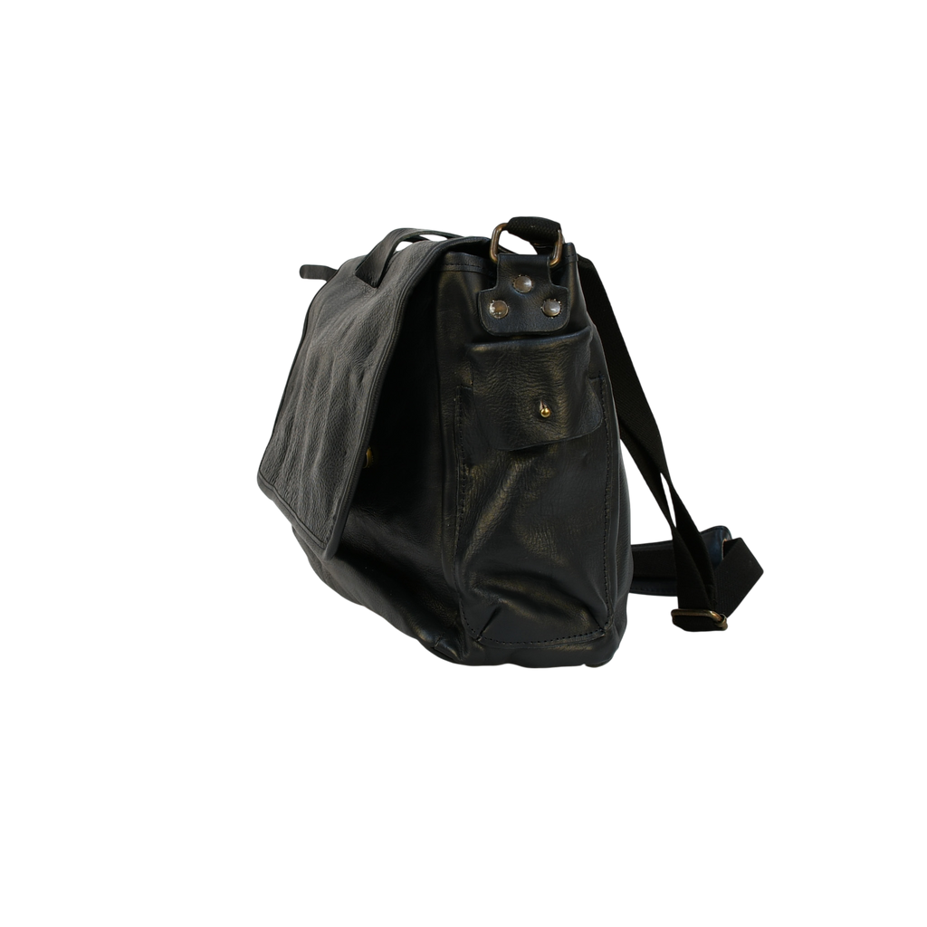 Black leather modern rugged messenger bag on a wooden table with a gray background