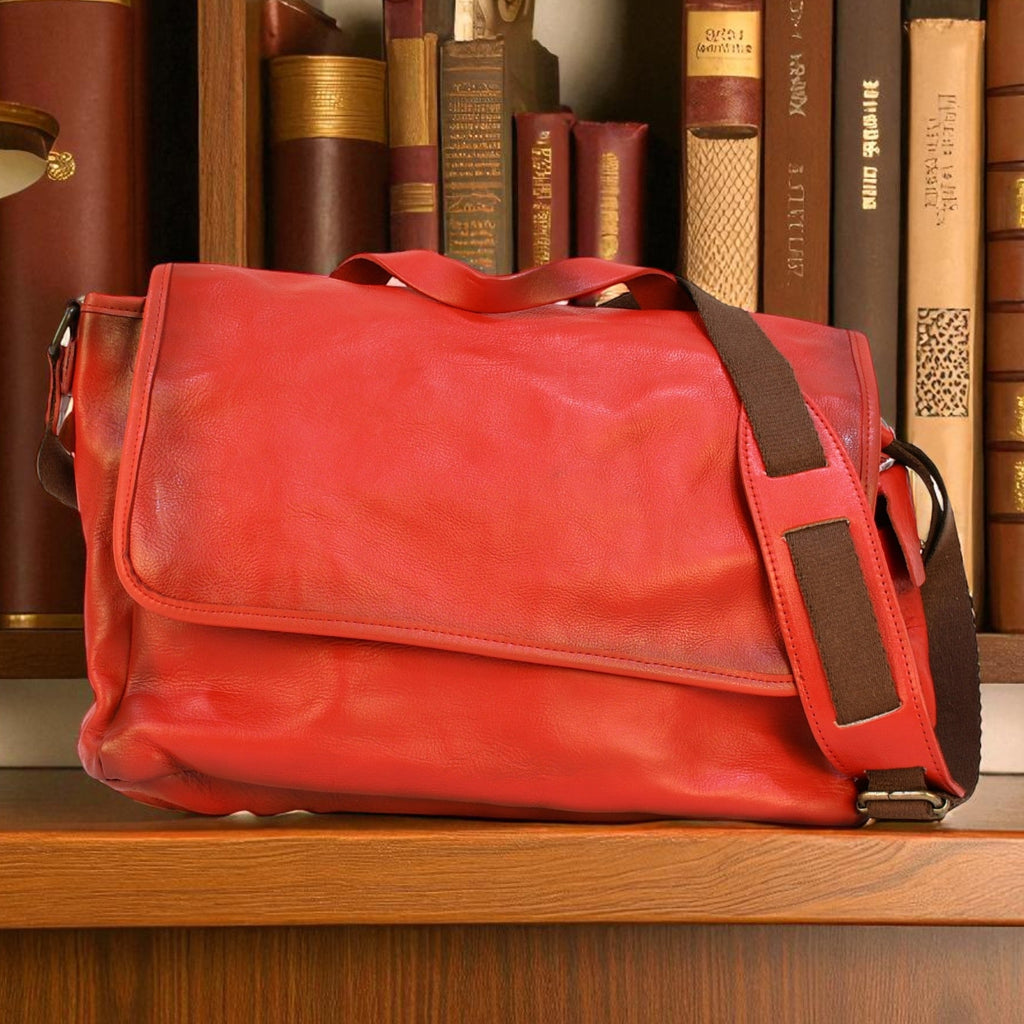 Red modern rugged leather bag on a wooden surface with books in the background