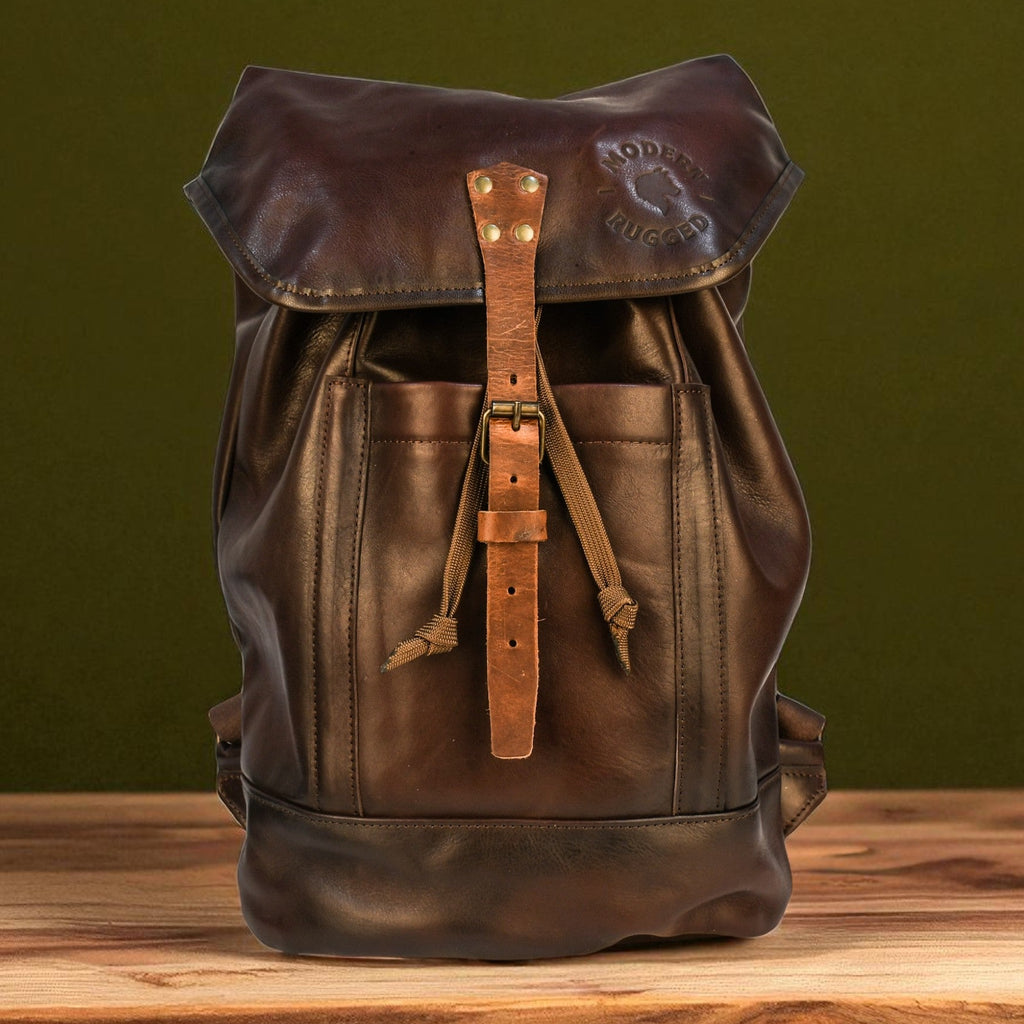 Brown leather backpack on a wooden surface with a green background
