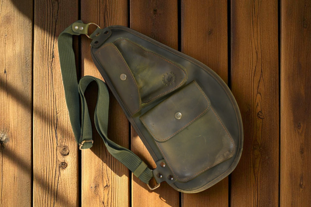 Green leather bag with a strap on a wooden surface