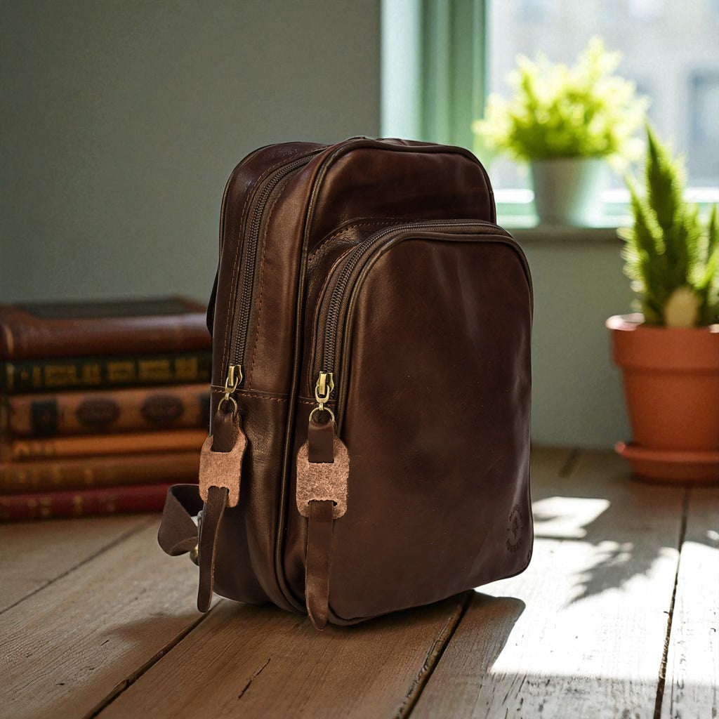 Brown leather backpack on a wooden floor with books and plants in the background