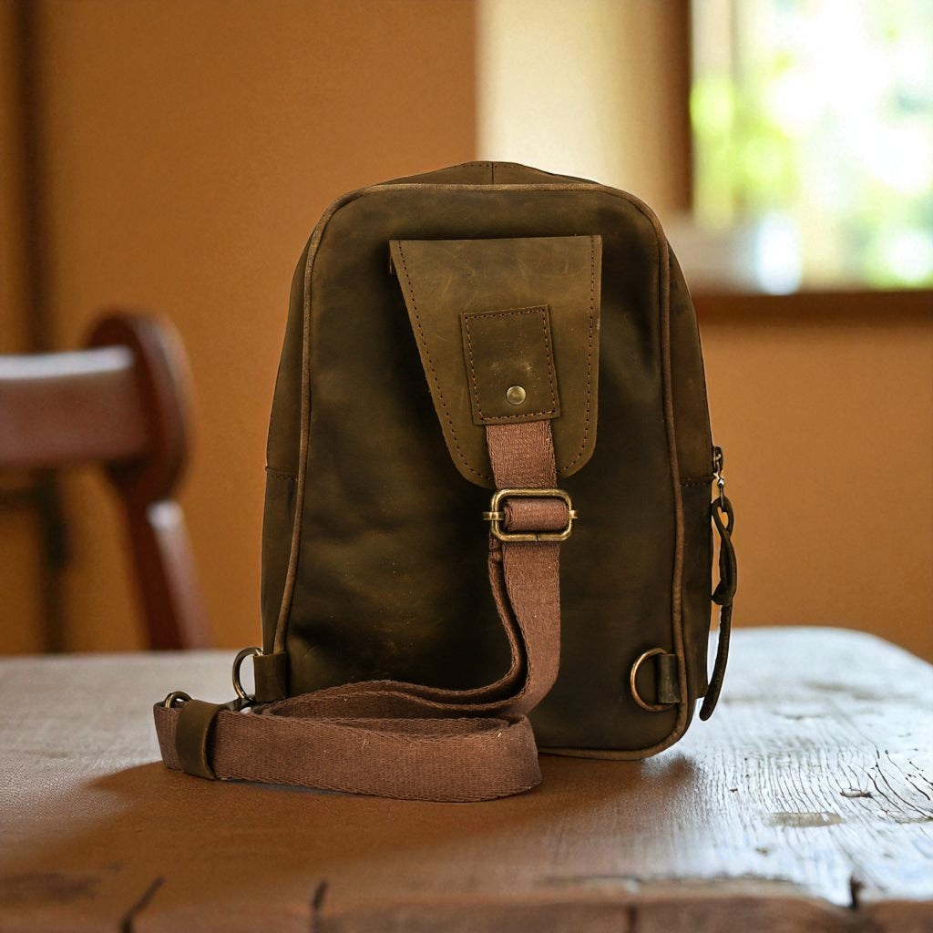 Green leather bag with a strap on a wooden table