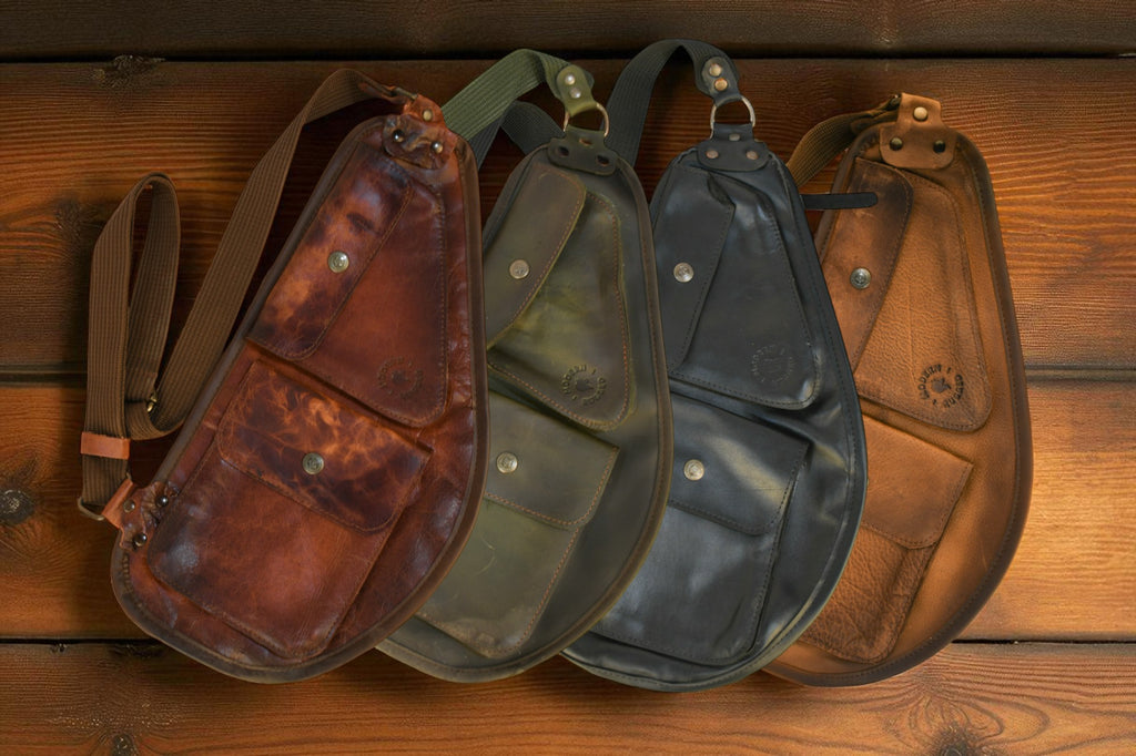 Four leather pouches in different colors on a wooden surface